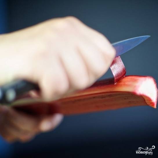 Ножом отрежьте верхнюю и нижнюю части стеблей ревеня, очистите стебли от верхнего слоя.