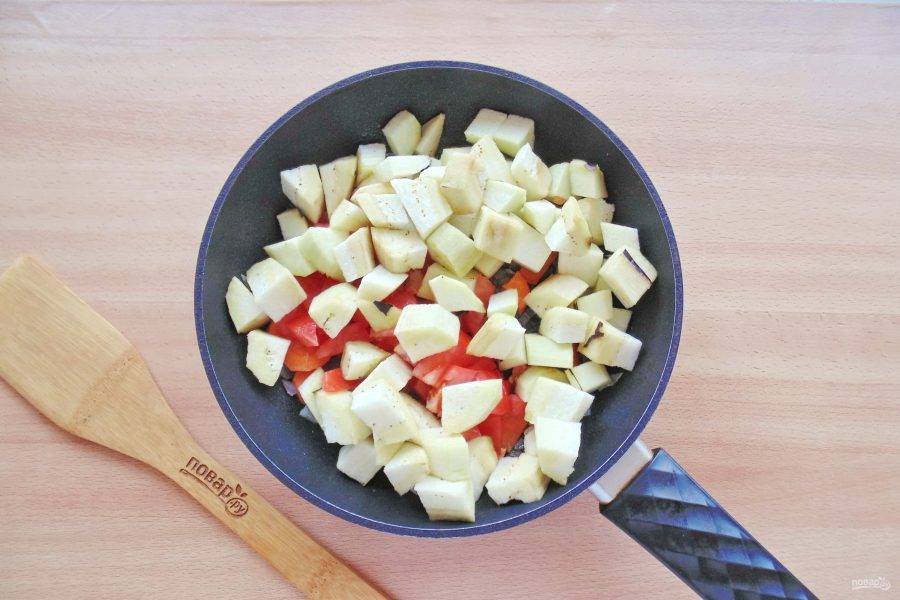 Баклажаны очистите, нарежьте кубиками и добавьте в сковороду с морковью, луком и помидорами. 