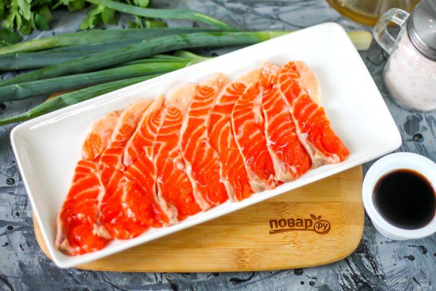 Филе лосося промойте в воде, острым ножом нарежьте его на слайсы и выложите их на тарелку.