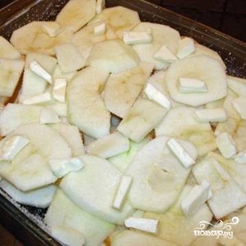 Самый верхний слой яблок нужно уложить внахлест, чтобы яблоки полностью накрывали собой все содержимое формы. Не забываем посыпать верхний слой сахаром и выложить на него несколько кусочков сливочного масла.