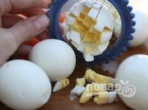 Яйца остудите, почистите и нарежьте кубиком.
