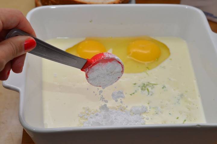 В удобной посуде венчиком смешаем сливки (или сметану), яйца, ванильную эссенцию, лимонную цедру и сахарную пудру.