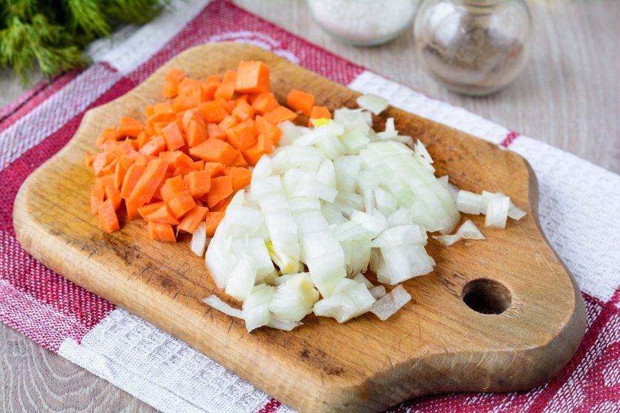 Измельчите овощи для зажарки. Лук нарежьте кубиками, а морковку натрите на терке.