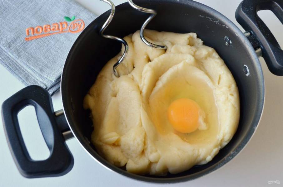 5. Приготовьте миксер с насадками для теста "крюк". В остывшее тесто вбивайте по одному яйца и тщательно миксером вымешивайте тесто. Не добавляйте следующее яйцо, пока предыдущее не будет полностью вмешано.