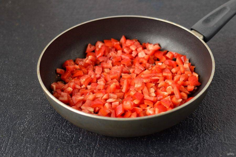Добавьте нарезанные кубиками томаты и болгарский перец. Обжарьте их 3-4 минуты. 
