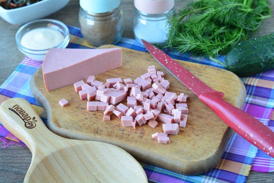Вареную колбасу нарежьте кубиками.