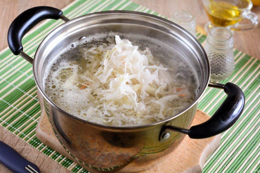 5. Всыпьте квашеную капусту и варите суп еще 10 минут.