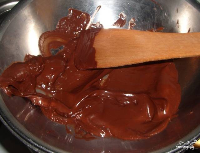 Плитку шоколада разломайте на квадратики. Подготовьте водяную баню и выложите шоколад в кастрюлю. Растопите шоколад, аккуратно помешивая его деревянной лопаткой.