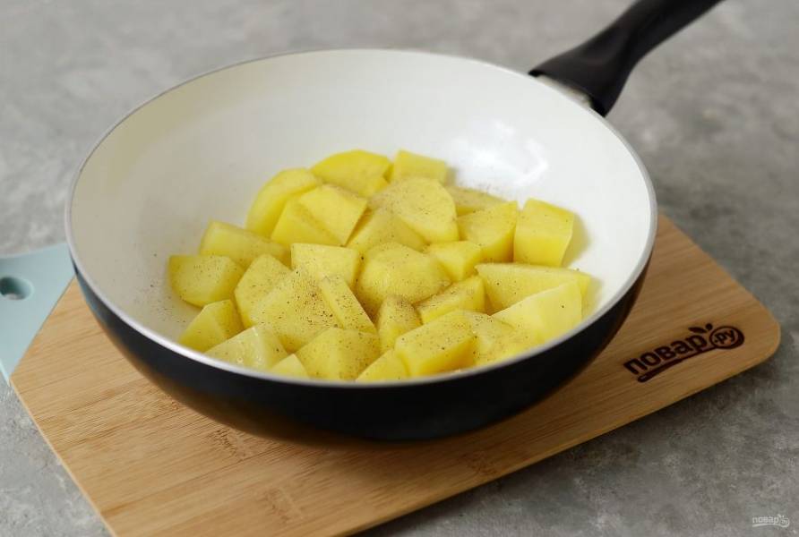 Разогрейте сковороду с растительным маслом. Выложите картофель, посолите и поперчите. Жарьте 5 минут на сильном огне, затем убавьте огонь и готовьте еще 20 минут, периодически помешивая.