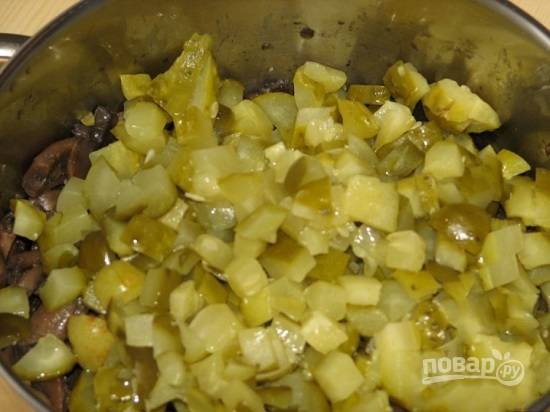 Маринованные огурцы нарезаем кубиками и отжимаем лишний сок.