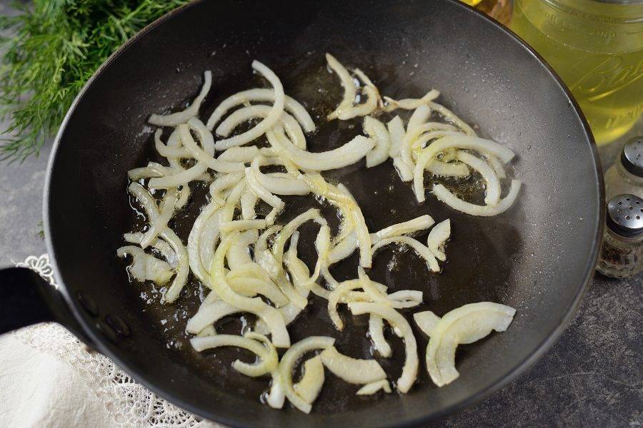 Разогрейте в сковороде растительное масло, обжарьте нарезанный полукольцами лук минуты 2-3 на умеренном огне. 