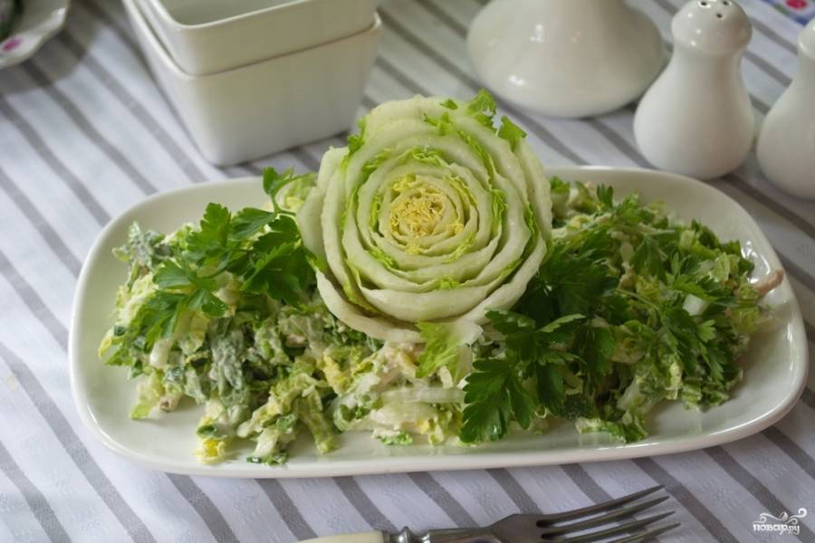 Заправленный салат уложите на прямоугольное или овальное блюдо.  В центре салата установите украшение из "попки" пекинской капусты. Она эффектно смотрится и напоминает цветок.