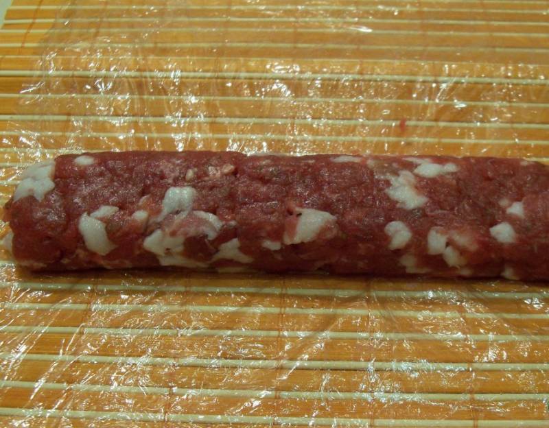 4. Мясо и сало смешаем и формируем руками колбаски. Оборачиваем их пищевой пленкой или  газетой в несколько слоев.