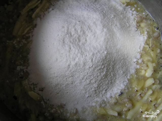 Соединяем крупу с картошкой, яйцами, специями, солью и маслом растительным. После тщательно перемешиваем массу. Добавляем тертый сыр и муку с разрыхлителем.