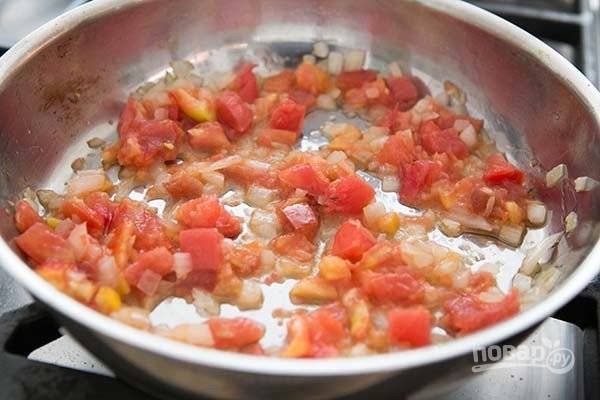 3.	Нарежьте кубиками лук и томаты, выложите сперва лук, готовьте его 3-5 минут, а затем добавьте томаты, тушите еще 2-4 минуты.