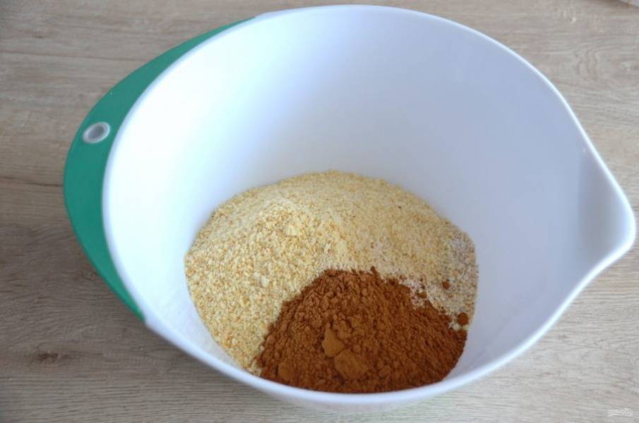 В миске смешайте измельченные овсяные хлопья, печенье (крекеры), добавьте 2 ст.ложки сахарного песка, всыпьте 2 ст.ложки какао-порошка, все смешайте.