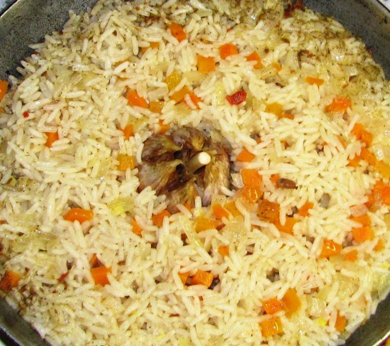 Накройте крышкой и варите в течение 25 минут на небольшом огне. После этого чеснок можно вынуть из блюда, очистить и добавлять по зубчику в каждую порцию. Рис с морковью и луком готов.