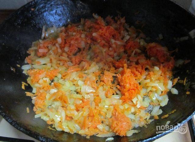 Затем в сковороду добавьте натёртую на мелкой тёрке морковь. Жарьте овощи до мягкости, помешивая.