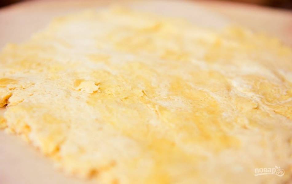 Готовое тесто раскатайте между двумя листами пекарской бумаги в пласт 5 мм толщиной.