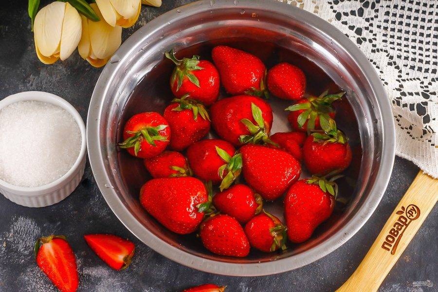 Выложите ягоды в глубокую емкость и промойте в воде. Удалите с каждой клубники хвостик.