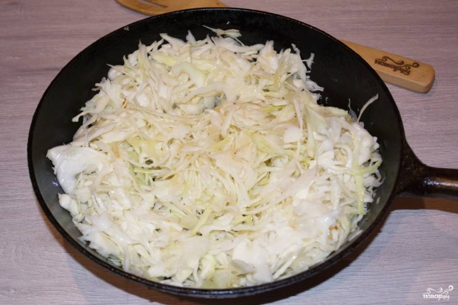 На растительном масле слегка обжарьте лук. Добавьте капусту — и сразу перемешайте. Если этого не предпринять, лук, оставшийся на дне сковороды, обязательно подгорит.