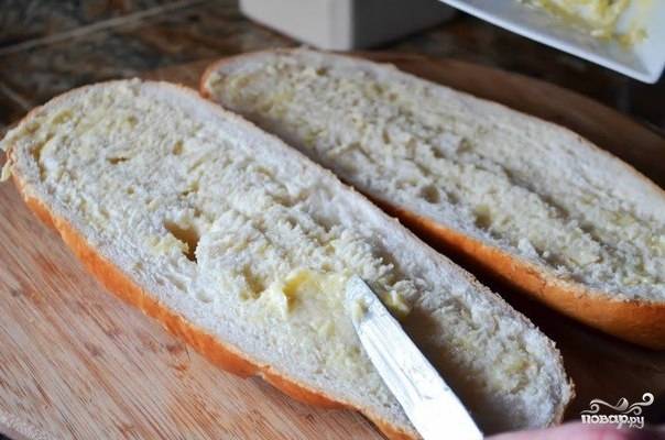 4. Распределите чесночное масло по поверхности хлеба. Чем больше будет чеснока, тем пикантнее получится закуска. 