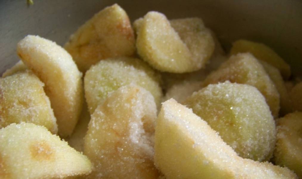 Засыпьте яблоки сахаром и хорошо потрусите кастрюльку, чтобы сахар распределился по всей емкости.