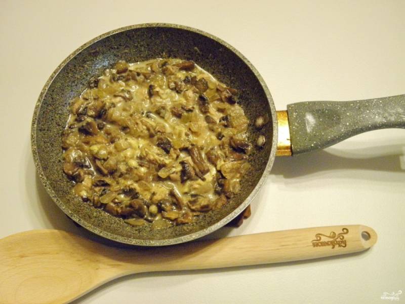В конце жарки налейте в грибы сметану, протушите всё вместе до испарения жидкости.