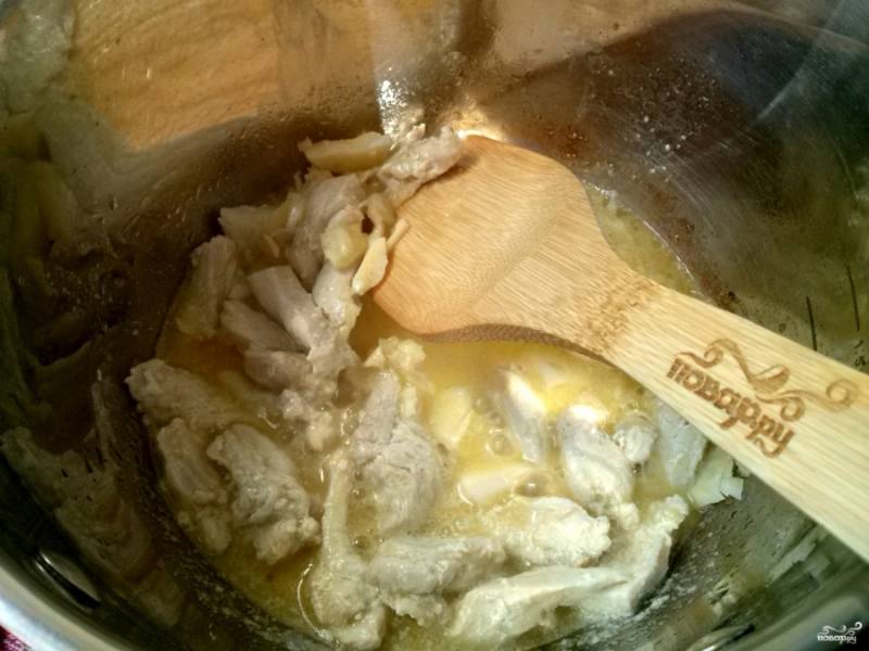 В кастрюле растопите сливочное масло, обжарьте куриное филе в течение 10 минут. Добавьте чеснок, все перемешайте.
