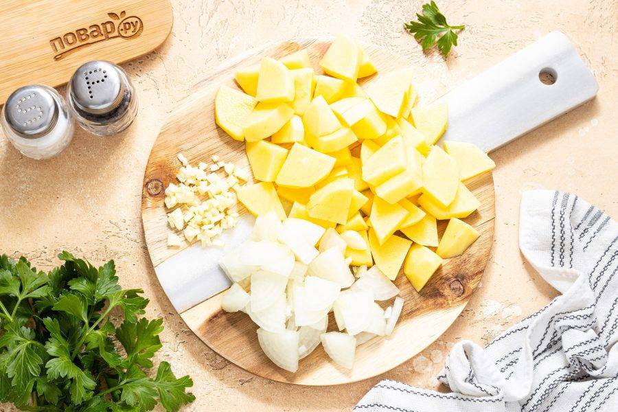 Нарежьте репчатый лук четвертинками, а чеснок крупно порубите. Картофель помойте, очистите от кожуры и нарежьте ломтиками средней толщины.