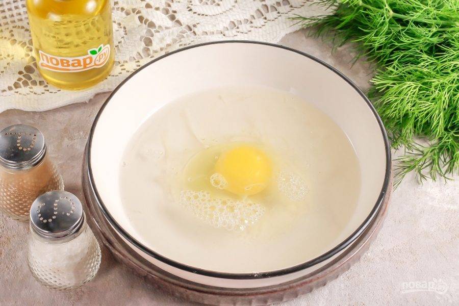 Вбейте в глубокую емкость куриное яйцо и влейте воду, всыпьте соль. Тщательно взбейте все содержимое емкости примерно 1-2 минуты.