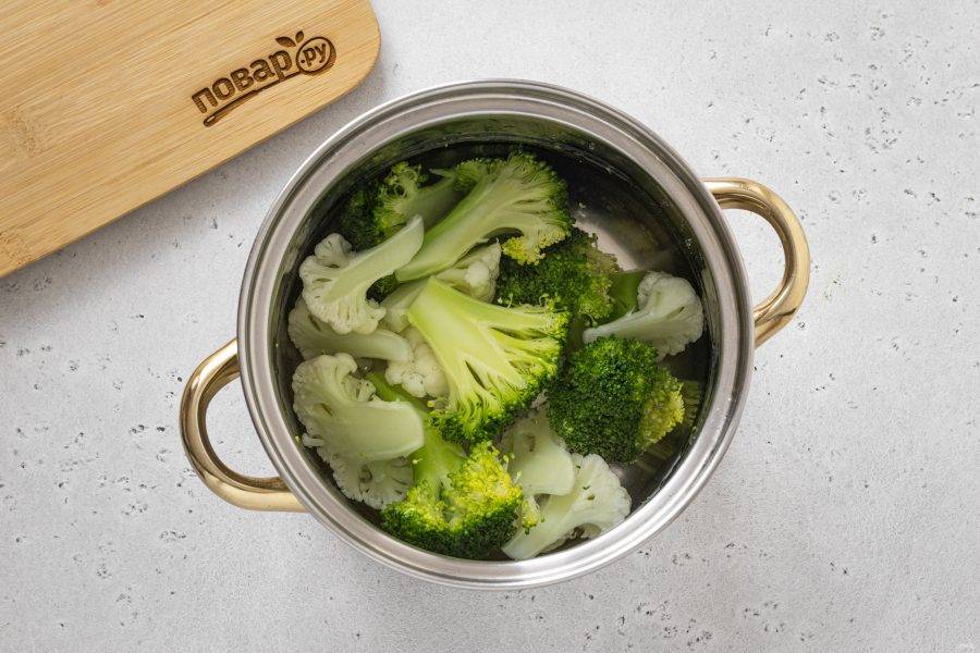 Отварите брокколи и цветную капусту в кипящей подсоленной воде 3 минуты. Слейте воду и откиньте овощи на сито.