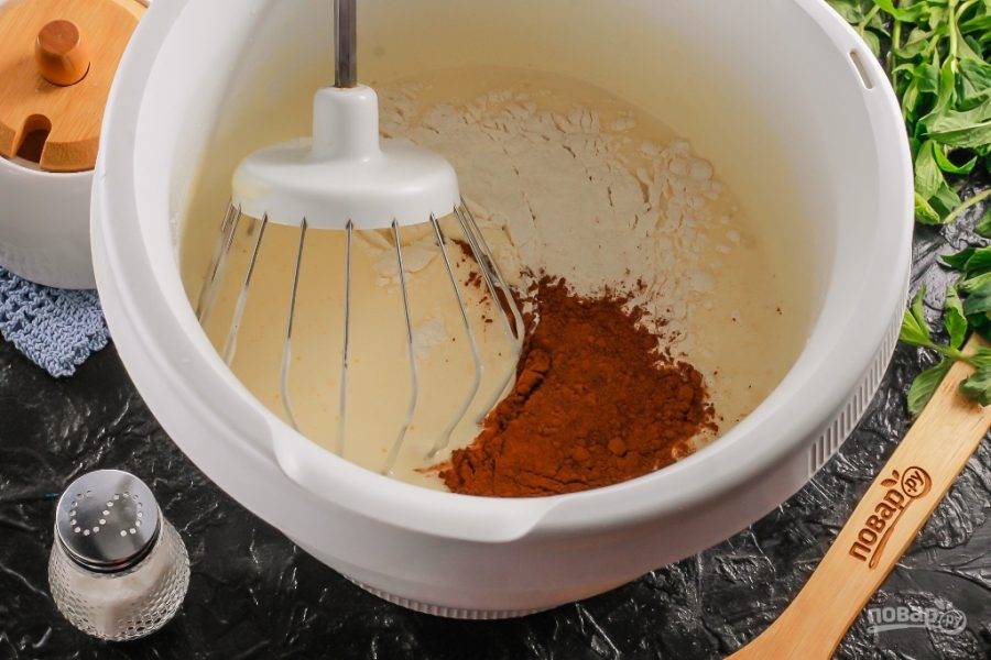 Всыпьте какао-порошок и пшеничную муку, аккуратно вмешайте ее во взбитую яичную массу, но не с помощью техники, а венчиком или силиконовой лопаткой.