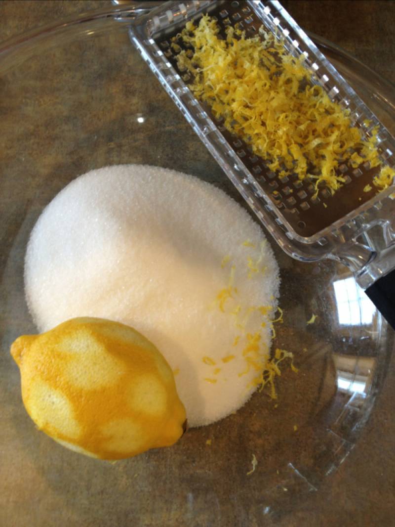 1. Подготовим ингредиенты. Лимон режем на половинки, выжимаем весь сок. Далее натираем цедру на мелкой терке. Смешаем все сухие компоненты: цедру, муку, сахар, соду и разрыхлитель. 