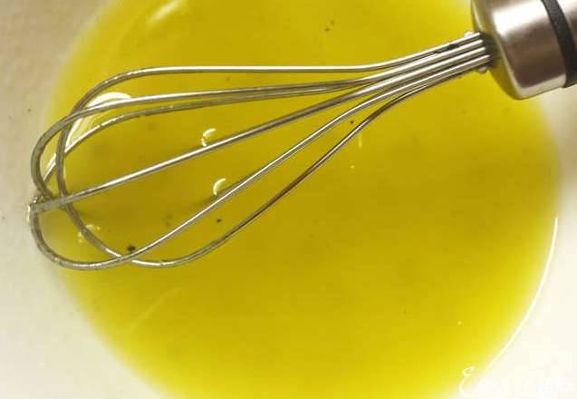 В миску наливаем оливковое масло, лимонный сок, добавляем мед, соль и перец, аккуратно все взбиваем при помощи венчика. 