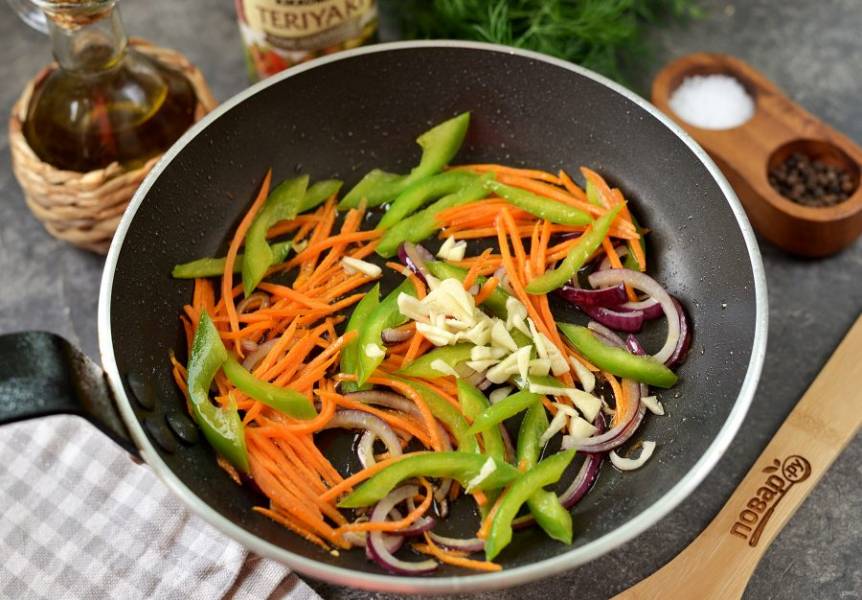 Снимите креветки на тарелку, а в это же масло выложите измельченный лук, морковь и болгарский перец. Обжарьте овощи минуты 2-3, добавьте чеснок. 
