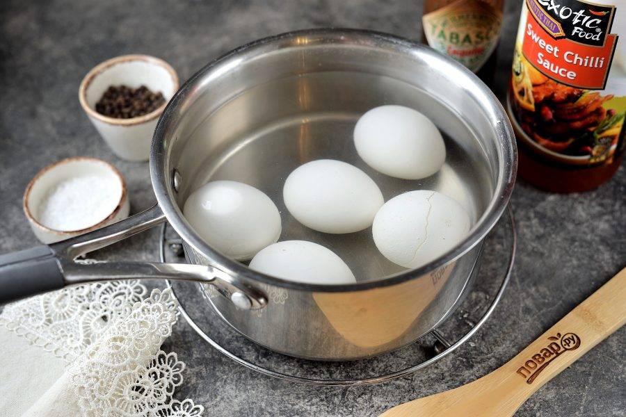 Переложите яйца в сотейник, залейте водой, поставьте на плиту. Отварите после закипания ровно 10 минут, затем залейте холодной водой и остудите их. 