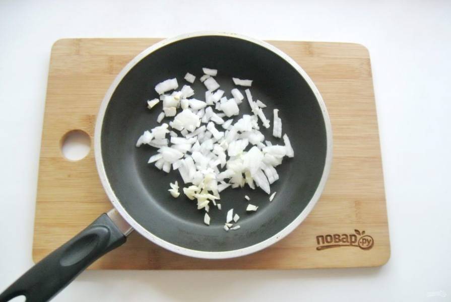 Зубчик чеснока мелко нарежьте и добавьте к луку в сковороду.