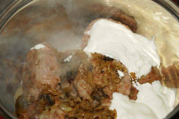Обжариваем зразы на горячей сковороде до румяной корочки. Затем перекладываем их в кастрюлю, присыпаем остатками грибов, добавляем сметану и пропариваем 30 минут.