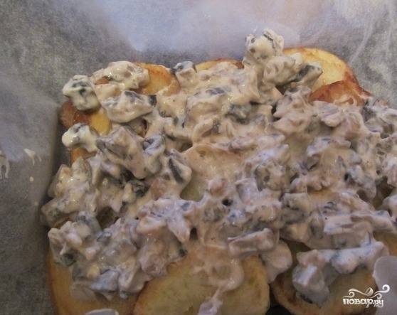 Теперь выложите на картофель тушенные в сливках грибочки. Они не должны быть слишком влажными, чтобы блюдо не растеклось в процессе запекания. 