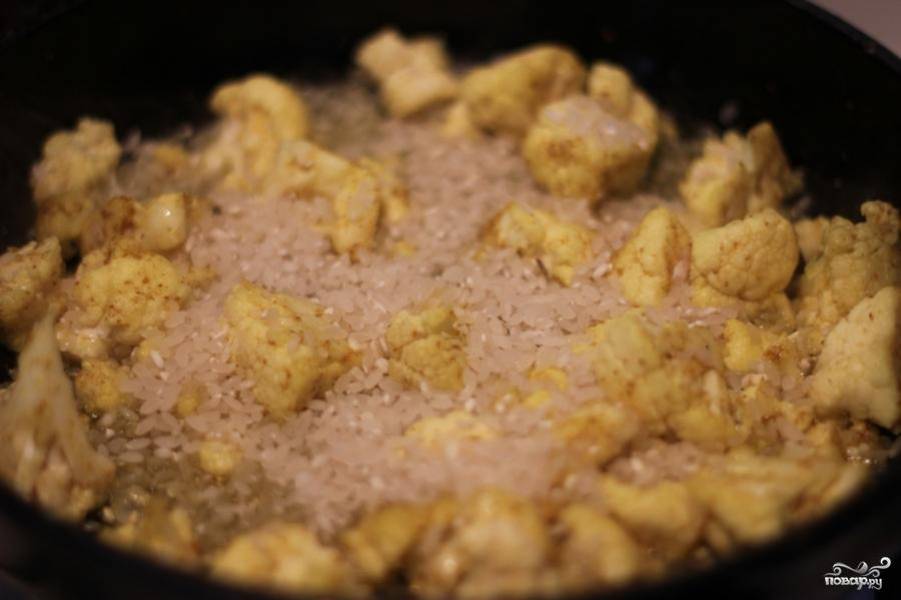 Цветную капусту обжарить на сковородке в масле в течении 2-3 минут на сильном огне. Затем к капусте добавить рис и обжаривать еще около 2 минут.