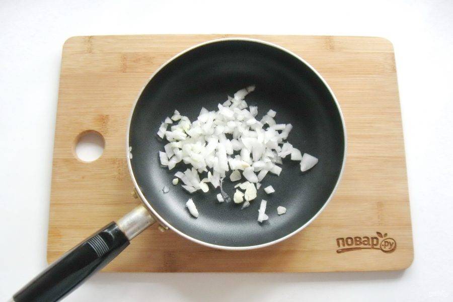 Одну небольшую луковицу очистите, помойте и мелко нарежьте. Выложите в сковороду. Добавьте нарезанный чеснок.