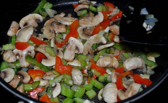 Мелко нарезаем болгарский перец, репчатый лук, сельдерей и шампиньоны. Обжариваем овощи с грибами на сковороде (примерно 4-5 минут). Специи — по вкусу.