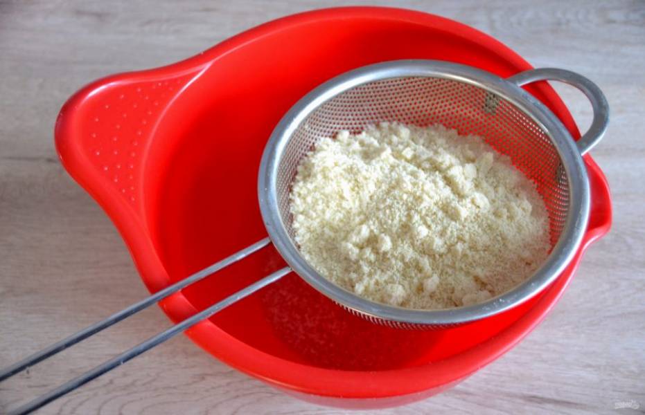 Для приготовления марципановой массы просейте в миску миндальную муку.