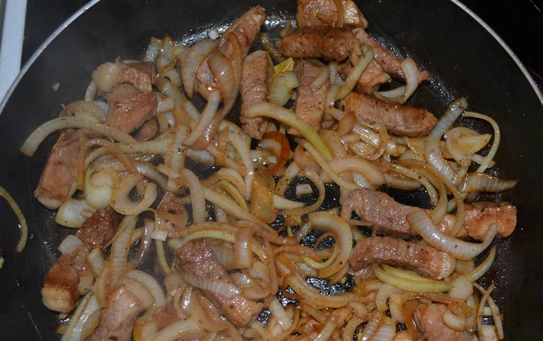 Разогреваем в сковороде растительное масло. Выкладываем мясо. Как только оно поменяет цвет и подрумянится нужно добавить лук.