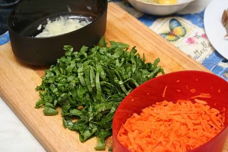 Подготовим остальные овощи: помоем и мелко порежем щавель. Очистим лук и морковь. Лук нарежем маленькими кубиками, а морковь натрем на крупной или средней терке.