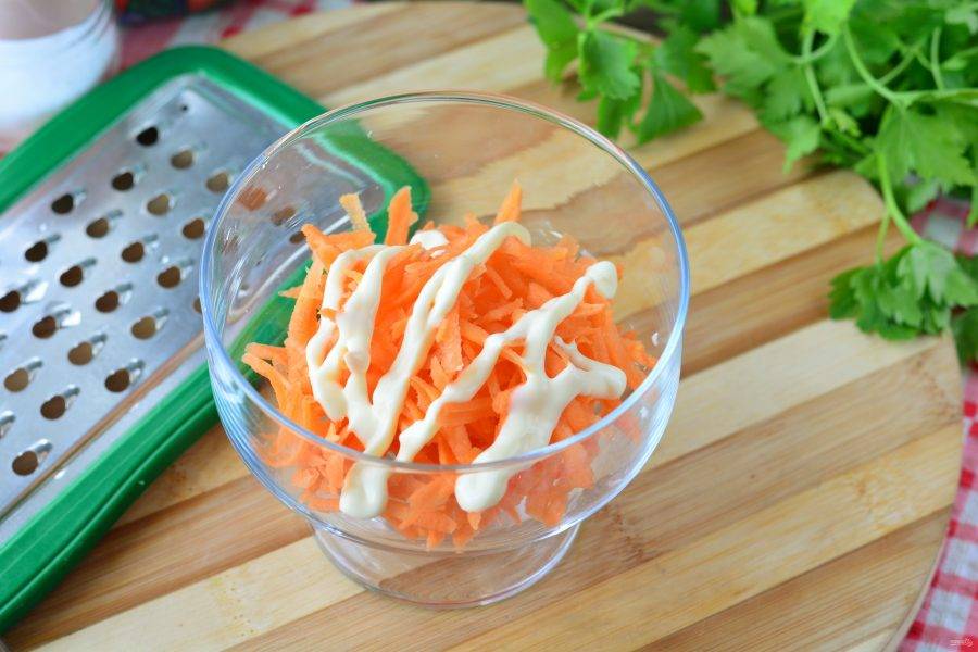 Выложите салат слоями, первым слоем распределите морковку. Полейте майонезом.