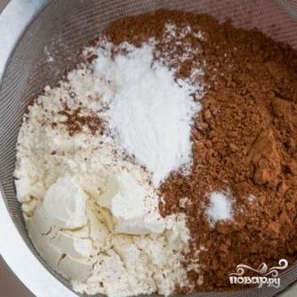 5. В отдельной миске смешайте муку, какао, щепотку соли и разрыхлитель. Просейте полученную смесь во взбитое тесто. 
