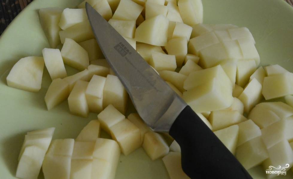 Картофель промойте, очистите и нарежьте кубиками.