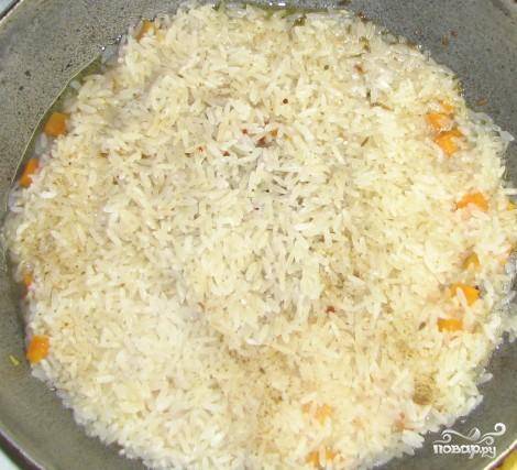 2.	Когда растопится сливочное масло, все перемешать и на овощную зажарку выложить рис. Выровнять его, посыпать солью и приправами.
